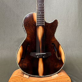 ボディーの奥行7.5cm Fホールにホロボディー、レスポールのようなフォルムでできたエレアコです。ピックアップマイクにはFISHMANを搭載しています。
			  本器はフレイムメイプルを採用したStyle2の特注カラーの『アクア』小振りであることからステージでの立ち回りも楽で、自宅練習ようのサブギターとしてお持ちになるのもオススメです。